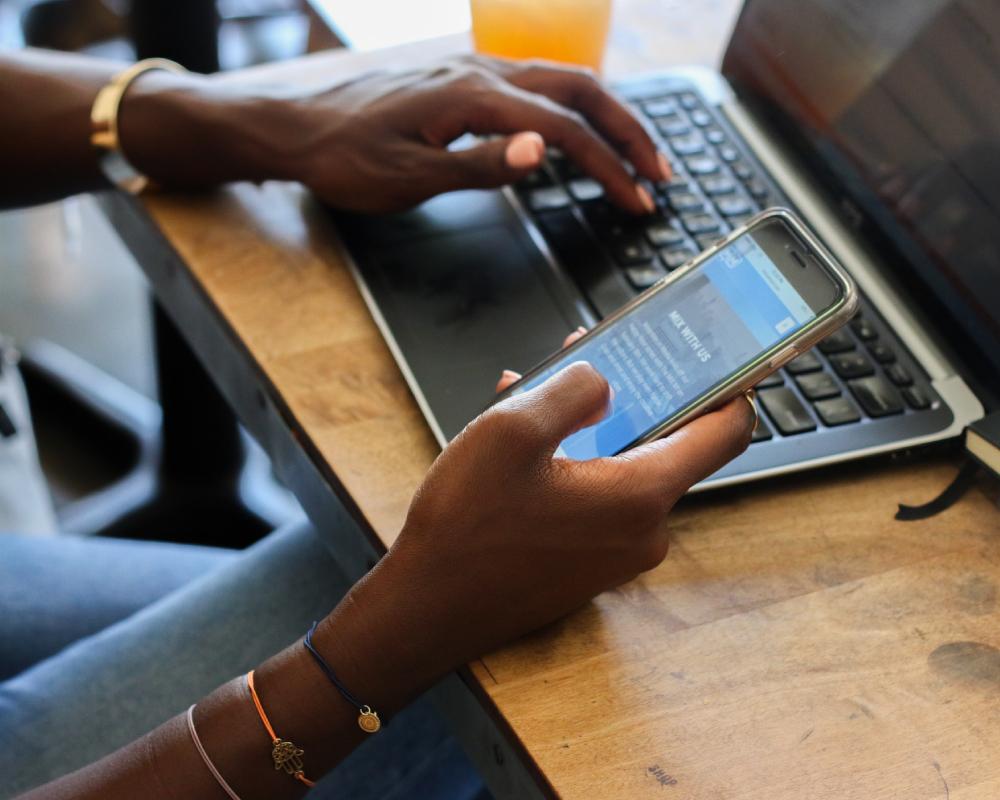 Engage your customers with mNotify: A woman uses her phone to connect with clients and build relationships